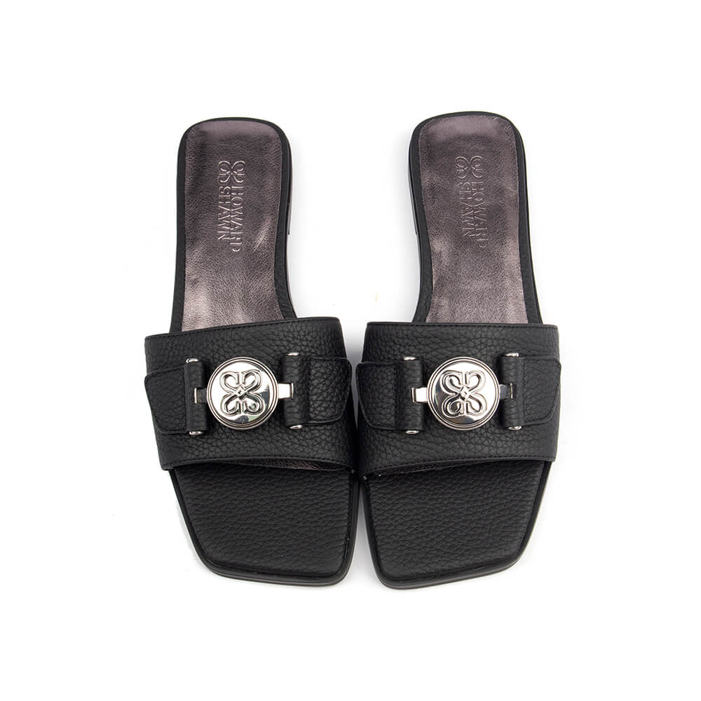 Versatile black flat slide sandal with logo medallion for everyday or dressy wear