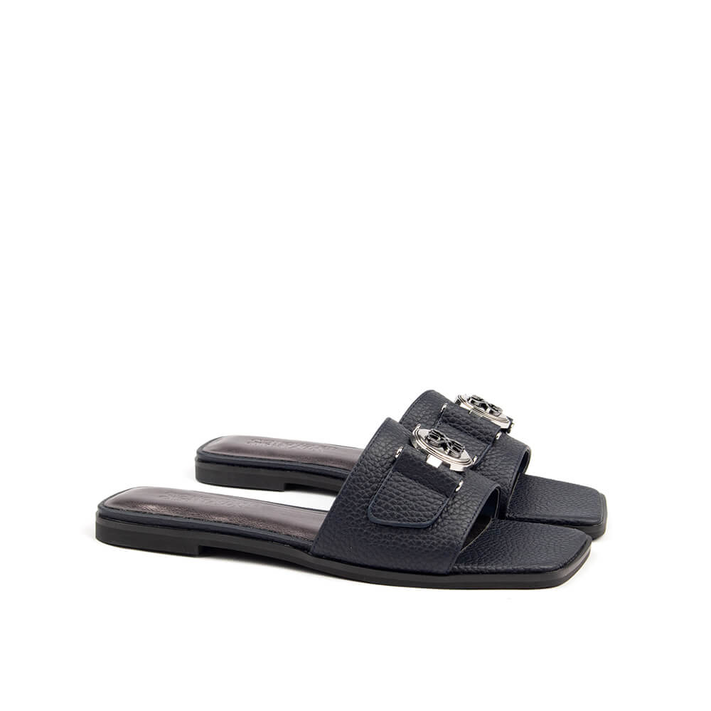 Top view of versatile navy flat mule sandal with silver logo for women