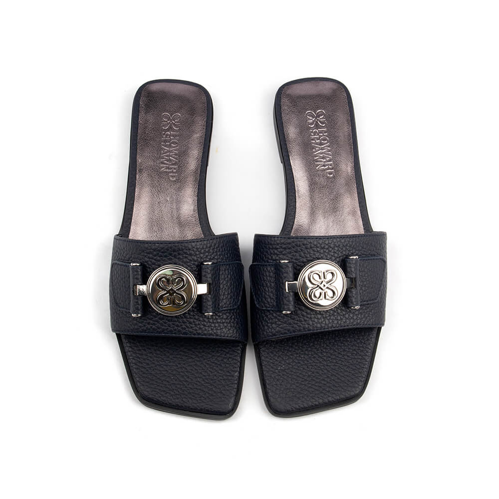 Top view pebbled navy leather flat slide with circular silver logo and dark sole