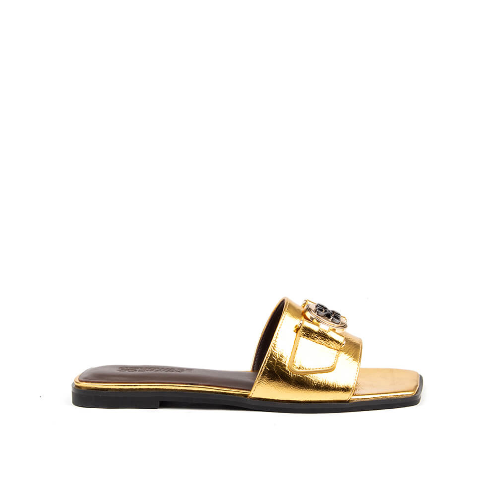 Gold metallic flat slide sandal with logo medallion buckle and square toe