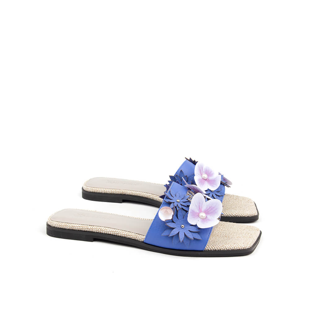 Women's flat mule sandals with blue leather flower appliqués and rhinestone footbed