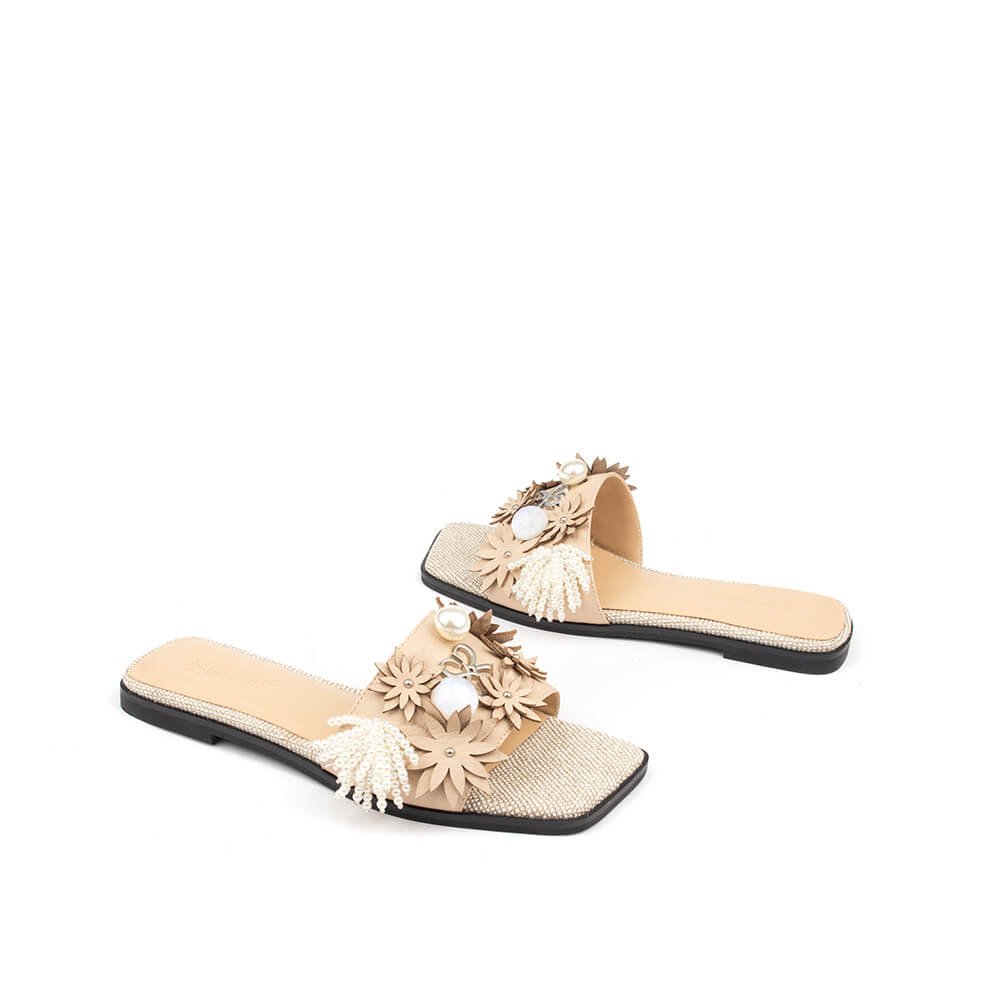 Nude leather flat slide with floral appliqué strap and sparkling crystal footbed