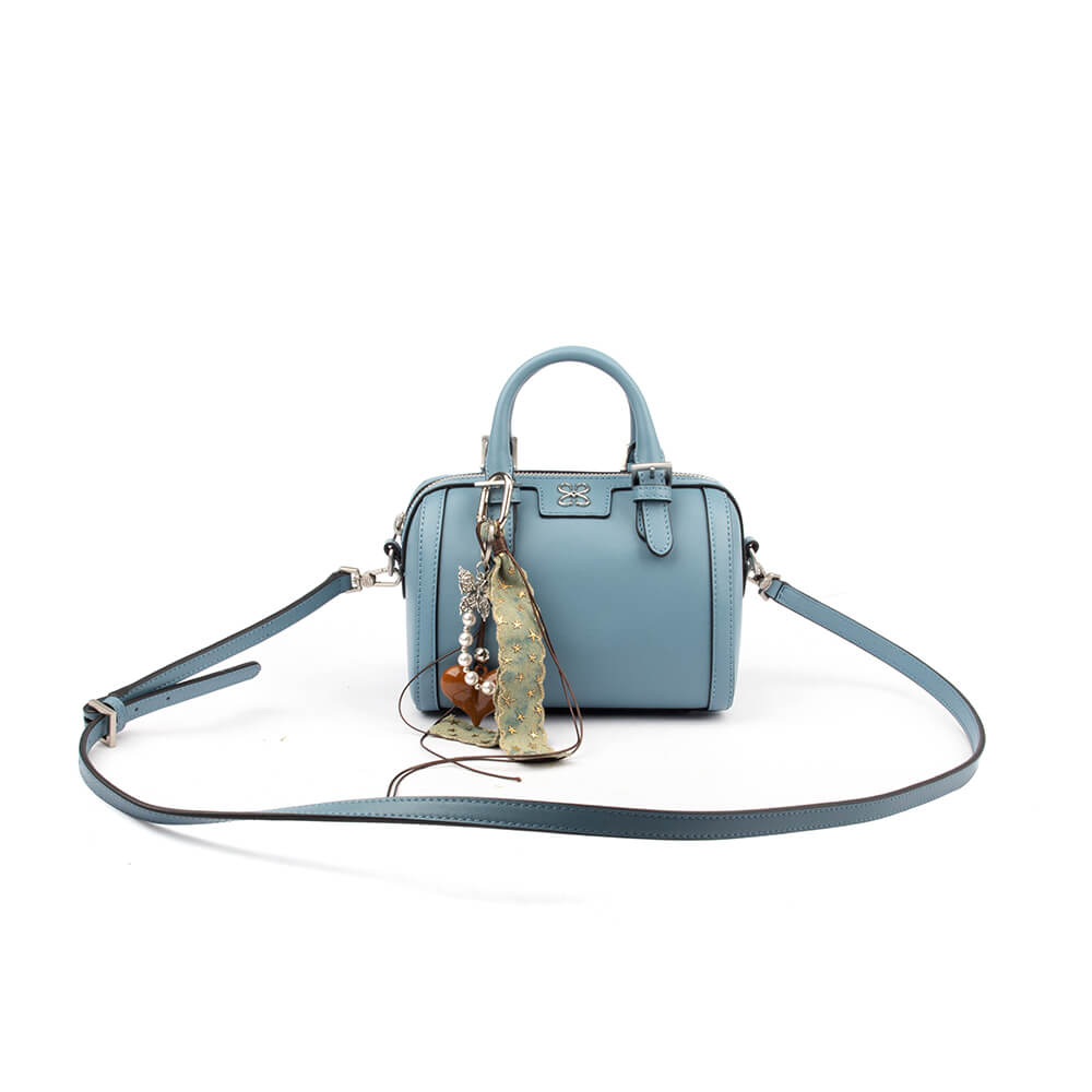 Small blue leather crossbody bag with carabiner pearl charm and lace pendant
