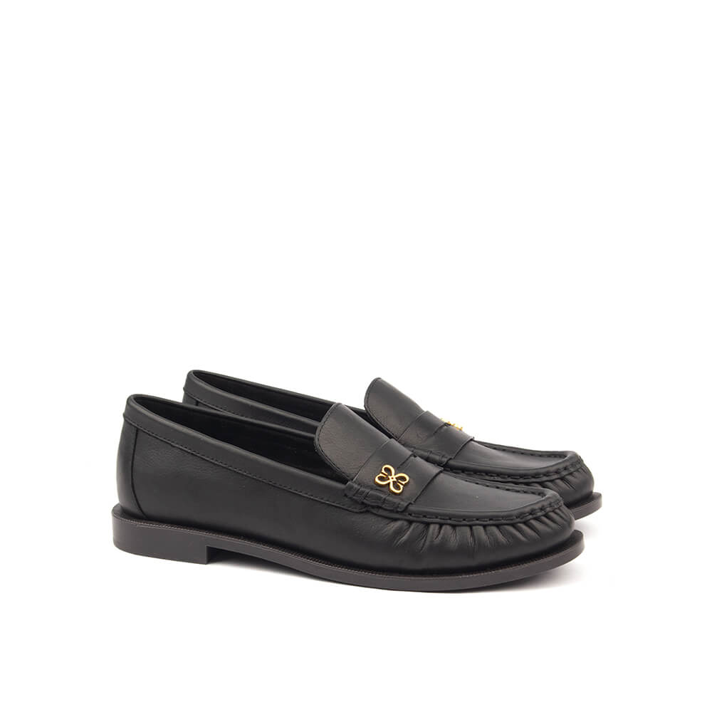 Classic jet black slip-on loafers with gold four-petal emblem for women