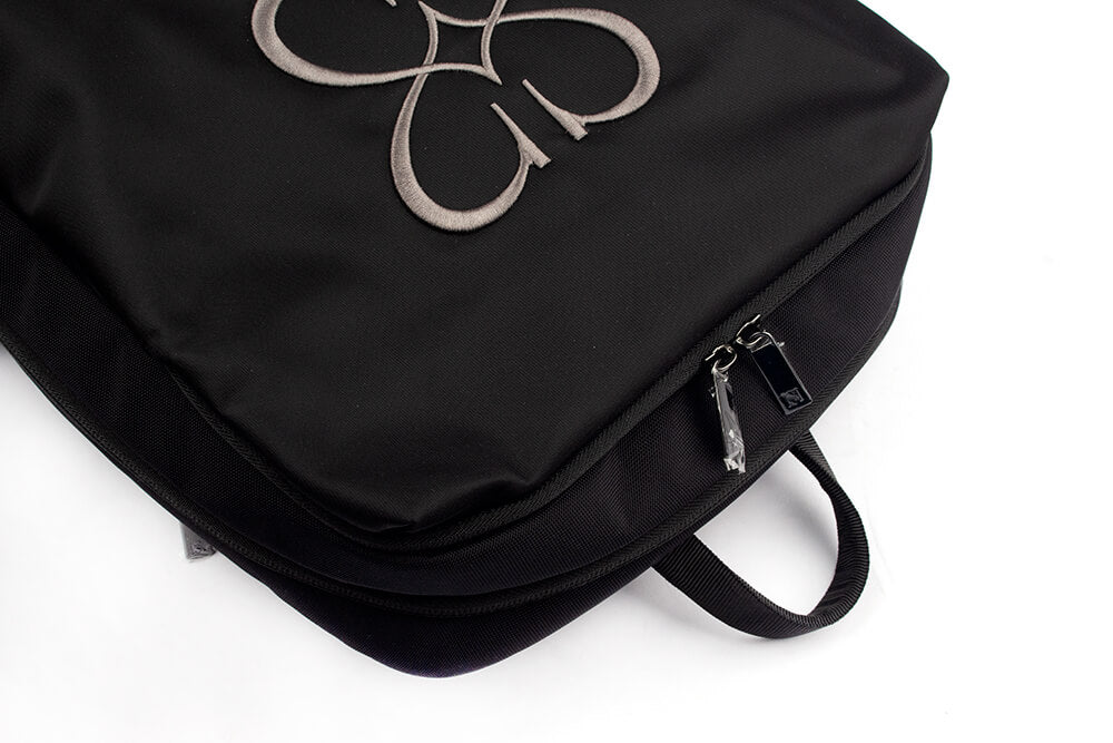 Sleek matte black backpack with embroidered Howard Shawn floral crest unisex bag